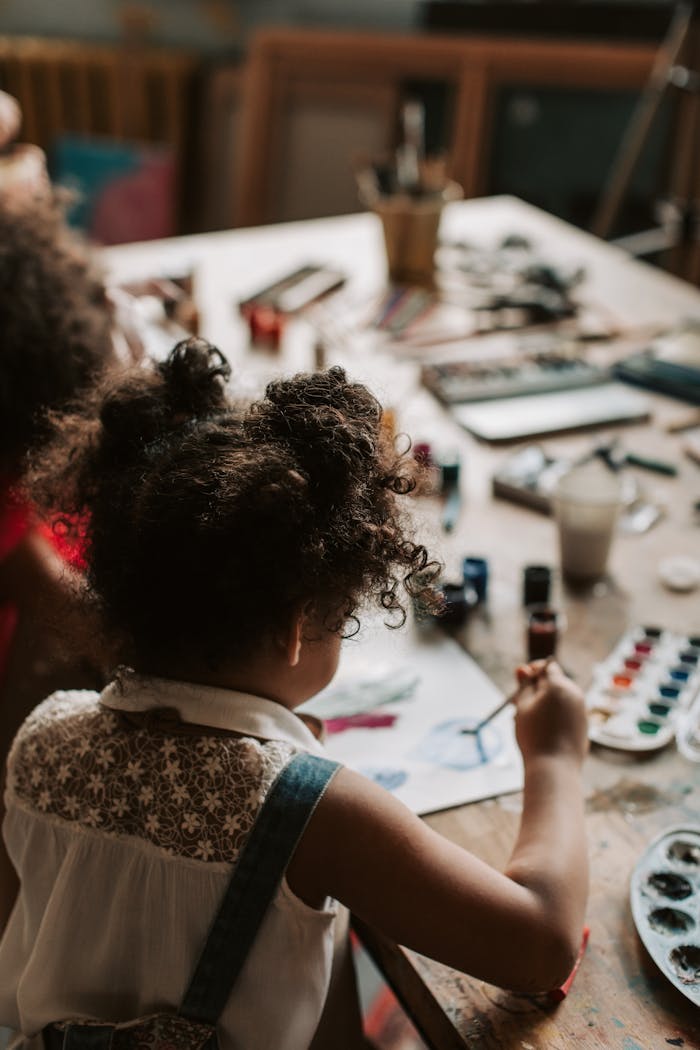 A child painting with watercolors at an indoor art studio.